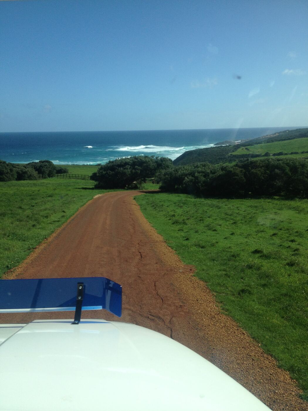 View from the cab down a gravel track towards the ocean