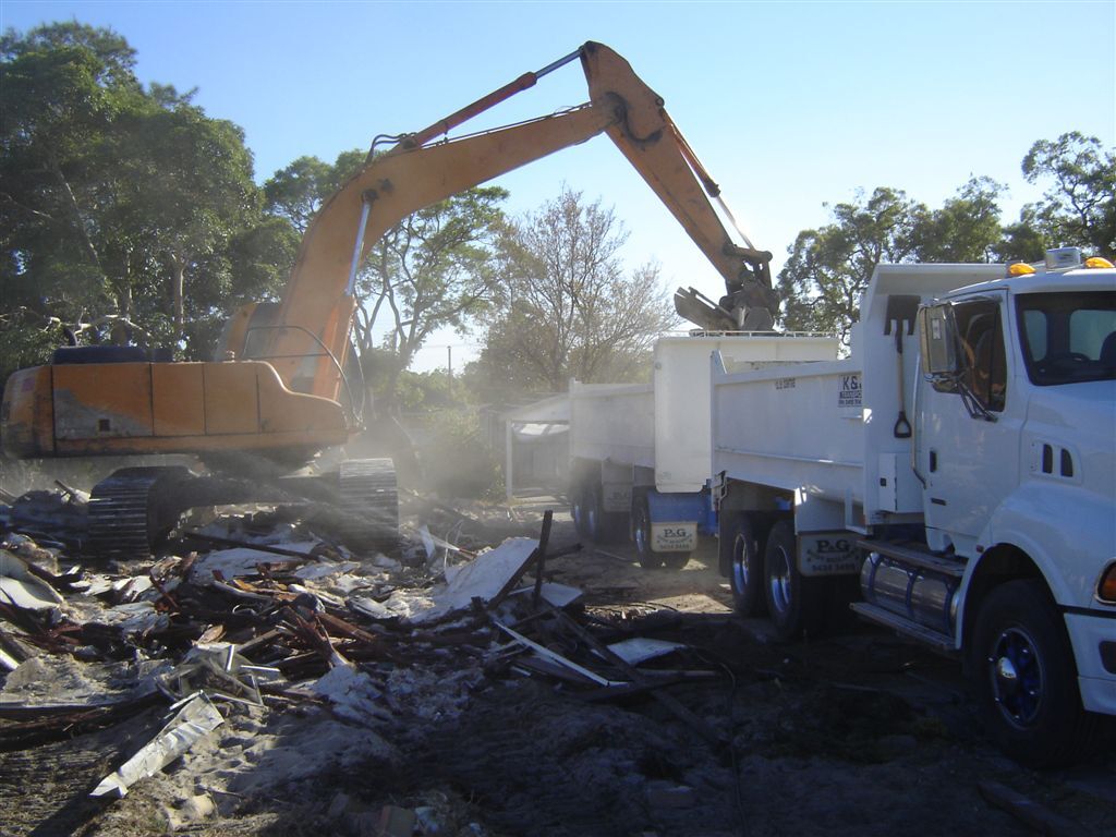 Excavator loading demolition rubble into a K & J tipper