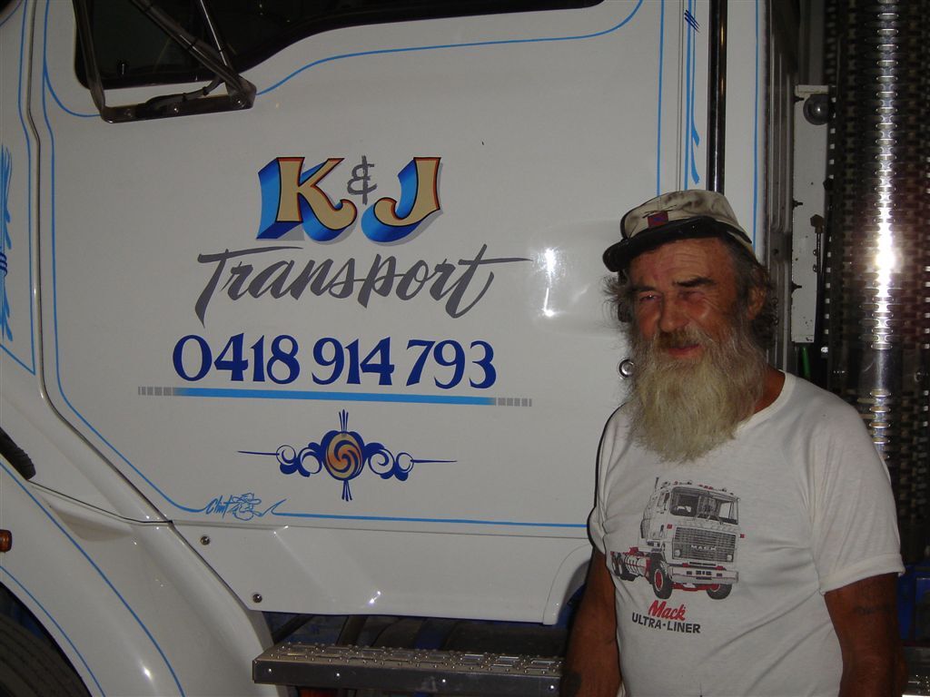 Kevin Dennis beside the K & J Transport door signwriting on one of the trucks