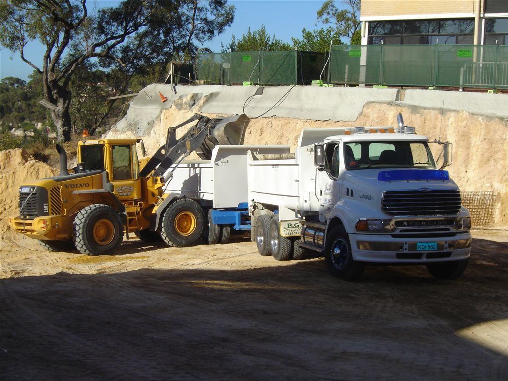 Loader filling a K & J tipper beside an excavation