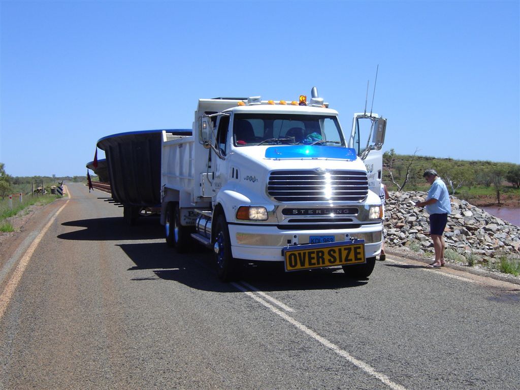 K & J truck carrying an oversize load along a regional highway